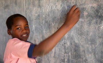 Ousman Haroum writes on the blackboard at school 