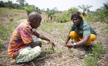 Concern Livelihoods Officer Sophia Johnny discusses climate smart techniques with farmer John Sakie at an agricultural demonstration plot in Grand Bassa County, Liberia. Photo: Kieran McConville