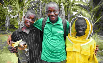 Concern Livelihoods Officer Benjamin Bundor (centre) with Daniel Johnson (L) and David Gargar (R) at the beekeeping project in Neakai, Liberia. Photo: Kieran McConville
