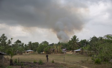 Smoke rising above a village in Rivercess County in Liberia.
