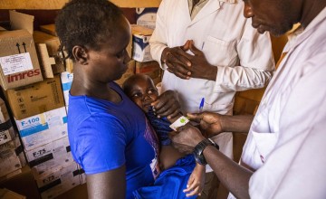Tatiana* and baby Arka* are checked by health assistant Alain Prospoer Ouafio (left) and Dr Thiery Kouda at Yaloké Secondary Hospital, supported by Concern. Photo: Ed Ram/Concern Worldwide