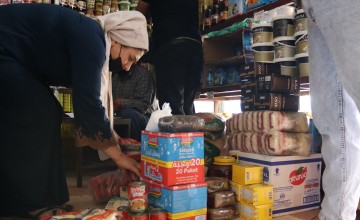 A woman chooses her food items from one of the shops where she purchases food with food vouchers in Kobani, Syria — part of an emergency food security program led by Concern Worldwide. Photo: Ahmad Al Aboud/Concern Worldwide