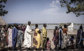 Nyepahan Ketket (in blue and yellow dress) is registered and given money in a cash distribution in Chotyiel, a settlement surrounded by flood water near Gwit, south of Bentiu in Unity State. Photo: Ed Ram/Concern Worldwide