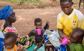 Dominique* feeds her orphaned grandchild Sylvie* in Bossembele-Yaloke, Pama Village, CAR
