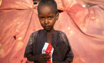 Abdul (5) at his family shelter in Lac Province, Western Chad. He is holding a packet of RUTF- a nutrient-rich paste prescribed to malnourished children. Photo: Eugene Ikua/Concern Worldwide 