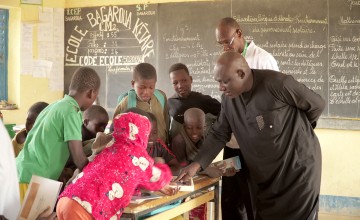 Children gather at school in Niger with two teachers 