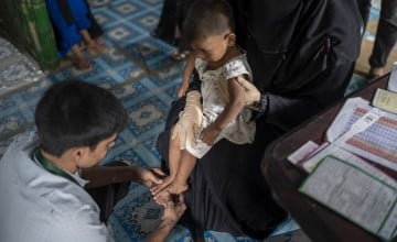 Sharmin* (27 months) is undergoing initial measurements after arriving at the Integrated Nutrition Centre in the camp. At the Anthropometric Measurement point in the centre, children first undergo an initial assessment, including MUAC (mid-upper arm circumference), weight, and height measurements to check for potential malnutrition and growth issues. Afterwards, they are referred to the PLW section for a rapid assessment by an assigned nurse, and necessary documentation is completed to register the case for