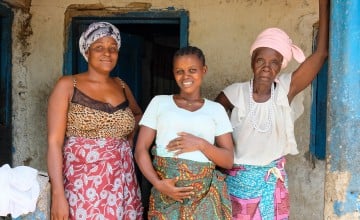 Pregnant mum Safinatu Kamara (22) with her aunt and grandmother at the family home in Mambolo, Sierra Leone. The health centre that Safinatu is attending for her pregnancy is supported by Concern. Photo: Darren Vaughan/Concern Worldwide