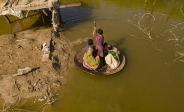 Aqib Aliin (14) transports people on his curry frying pan across the flooded waters in Jhuddo town of District Mirpurkhas of Sindh, Pakistan, following the devastating floods in 2022.