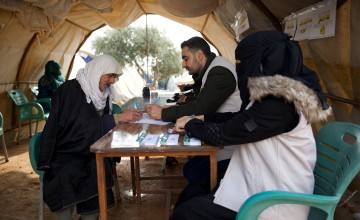 Omar* (66) receives a cash voucher distributed from Concern partner Syria Relief. Basil Kharouf and Ibtisam Al-Khanous help him fill out the necessary papers. Photo: Ali Haj Suleiman/DEC/Fairpicture