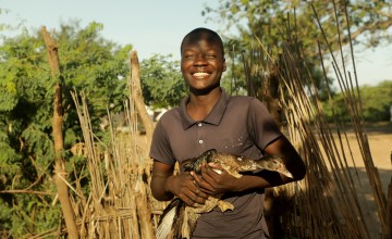 Young farmer Andrew Mithapa (21) lives with his mother Monica Simbi (47) and siblings under the shadow of a great Baobab tree. As participants in Concern's Graduation Programme, funded by Irish Aid, they received chickens, ducks, and a camera-shy pig from Concern, with which they've been able to support their young family. Photo: Jon Hozier-Byrne/Concern Worldwide