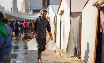 Mohammad takes containers to refill at a water distribution point in Gaza, supported by Concern and Alliance2015 partner CESVI. Photo: Abood Al Sayd/DEC