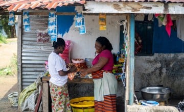 Emma with a customer as she sells to residents in her community, Liberia. Photo: Eugene Ikua/Concern Worldwide.