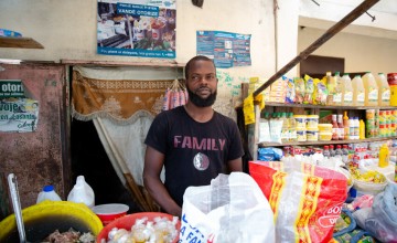 A participating vendor of the Manje Pi Byen programme, at his stall in a street market in Cité Soleil, Port-au-Prince. Photo: Kieran McConville/Concern Worldwide.