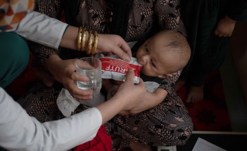 A Family Health House midwife in Takhar Province feeds Tahira*'s infant son, Faris*, ready-to-use therapeutic food (RUTF) as part of his treatment for malnutrition. Photo: Nava Jamshidi/Concern Worldwide