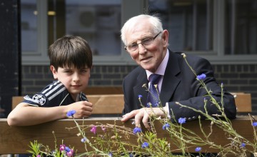 young boy and elderly man looking at the camera having just received volunteer awards