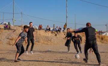 Footballer and Concern Ambassador Michael Darragh MacAuley joins in on a game with residents of a displacement site in northwestern Iraq. Photo: Gavin Douglas/Concern Worldwide