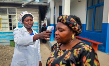 Doctor taking temperature check of woman