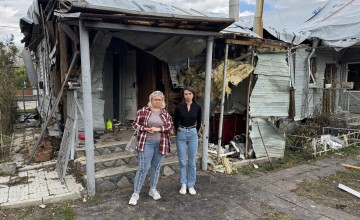 Sofiy* and her mother* Zoya outside the wreckage of their home in Ukraine
