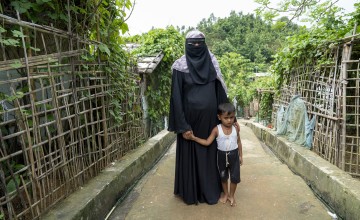 Rihana* (28) with her child in her yard in Cox's Bazar.