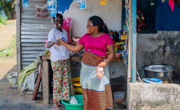 After years of struggling to support her family through selling fish and charcoal, Emma Johnson began saving through her local CSLA and took a small loan to open her own shop. The business is already busy, and Emma says it has brought stability and pride back into her home. 