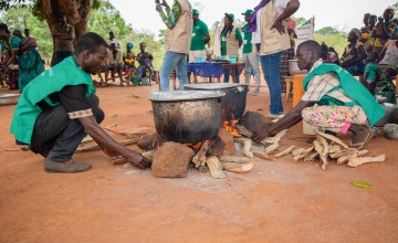 Concern staff members cook nutritious porridge as mothers and their children patiently wait. Photo: Mussa Uwitonze/Arete/Concern Worldwide.