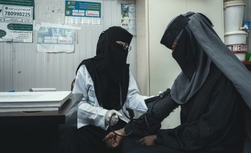 Nurse taking blood pressure of woman