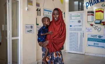 Faizah holding her daughter Malliya in health centre 