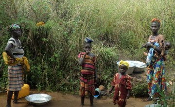 Residents of Bekadili village stand beside a small spring that is used to collect water for drinking, cooking and other household needs. Photo: Crystal Wells/Concern Worldwide.