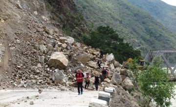 Bulldozers working to re-open a road in Khurkot, Ramechhap  after the recent earthquake in Nepal, with a newly-built bridge in the background. Photo taken by Helvetas. 