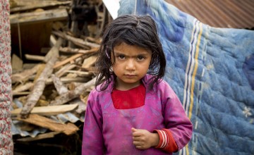 Shiwani Sapkota, in front of the remains of her home in the village of Kukhretar, Kabhrepalanckok district, Nepal. It was destroyed by the 25 April earthquake and she and her family are now homeless. Photo taken by Crystal Wells / Concern Worldwide.