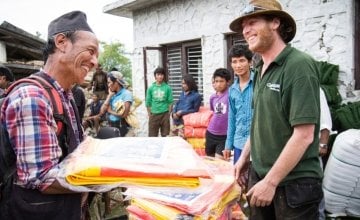 Concern Worldwide's Dom Hunt distributes tarps in Mane Banjang, a community high in the foothills in Sindhupalchok district, one of the hardest hit areas by the 7.8-magnitude earthquake that struck Nepal on 25 April. Photo taken by Crystal Wells / Concern Worldwide.