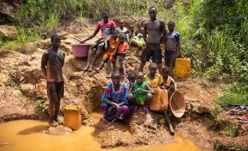 Residents of Gaga village gather beside a local spring, that is often used by locals to mine for gold, to collect water for drinking, cooking and other household needs. Photo: Crystal Wells/Concern Worldwide.