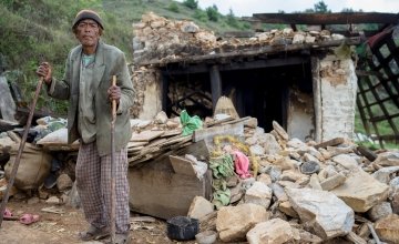 Pasairingi Sherpa, 60 years of age, stands outside his home in in Hawa VDC, Ward 6, Nepal that was destroyed in the earthquake. Photo taken in June 2015 by Brian Sokol/Concern Worldwide.