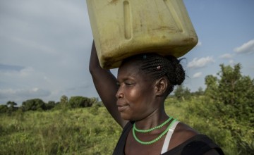 Santina Lalam, a farmer from Agago in Uganda, carries a jerry can on her head to collect water.