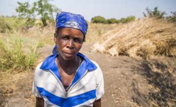 Lucia White in front of the site of the home she lived in for 20 years in Nsanje, Malawi. The house was washed away by the floods of January 2015. Lucia has been helped by Concern with emergency supplies and with seeds, fertilizer and goats. Photograph taken by: Concern Worldwide/Kieran McConville.