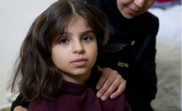 Eight year old Khadiya* with her mother Haya*. Khadiya and her family fled Syria as refugees and now live with three other families in a two-roomed flat in northern Lebanon. Photograph taken by Abbie Trayler-Smith/Panos for Concern Worldwide in December 2015.
