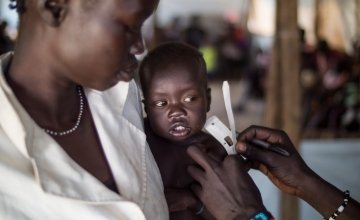 12 month old Gatlit Matiek, pictured with his mother, Nyekliony Bany Gaie. has his upper arm circumference measured at one of the Concern nutrition centers in Bentiu Protection of Civilians (POC) site in Unity State, South Sudan. Photo: Kieran McConville/Concern Worldwide 2016.