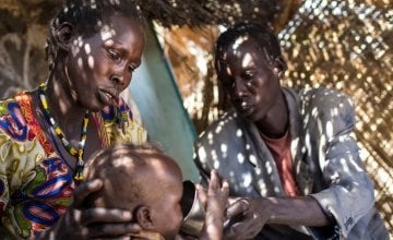 Atuil Chok with her husband, Adim, with their fourteen month old twins, who have both been acutely malnourished and are attending the outpatient therapeutic programme run by Concern in Maduany in Aweil North, South Sudan. Photo: Kieran McConville/Concern Worldwide.