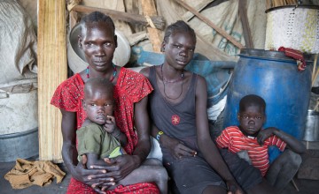 37 year old *Sahra, with two of her five children, outside their temporary shelter in the swamps of Unity State, South Sudan. She came here to flee fighting in her home town. Photo: Concern Worldwide. 