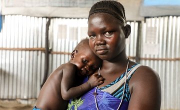 Nyakoun Tut stands with her baby Thujin in a Concern supported nutrition centre in Pudnigo 1 refugee camp in Gambella, Ethiopia. Photo: Jennifer Nolan / Concern Worldwide. 