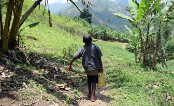 Nishimwe from Burundi makes a two hour journey to school on foot carrying a small container filled with water. Photo: Darren Vaughan/Concern Worldwide.