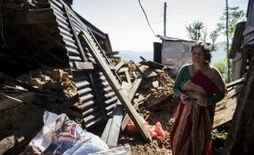 In a Nepalese village, Chandra stands amongst the wreckage of her home. Photo taken by Crystal Wells/Concern Worldwide