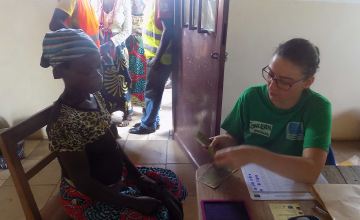 Joanne Cagin, Concern’s Livelihoods Programme Manager, making a cash transfer to a beneficiary in the Concern office close to Ankoro town in DRC. Photograph provided by Joanne Cagin/Concern Worldwide.