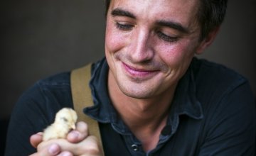 TV host and cook, Donal Skehan, with a Malawian chick in Jambawe village, Malawi. Chicks like this can be donated to Malawian communities through Concern Christmas Gifts. Photo: Jennifer Nolan/Concern Worldwide.