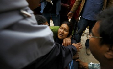 Rescue team member works to dig out the trapped body of a woman from a collapsed house a day after an earthquake in Bhaktapur, Nepal April 26, 2015. Rescuers dug with their bare hands and bodies piled up in Nepal on Sunday after the earthquake devastated the heavily crowded Kathmandu valley, killing at least 1,900, and triggered a deadly avalanche on Mount Everest. REUTERS/Navesh Chitrakar