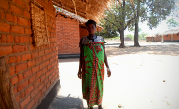  Christina stands outside her home in rural Malawi. Photo taken by Alice Gandiwa.