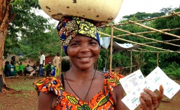Wiligala Isabelle from Kenenge village is pictured holding her vouchers used to purchase seeds and tools at a seed fair organised by Concern. Photo: Concern Worldwide.