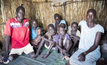 Nyadom Machar Raynem (far right), 48, James Gatchang (far left), 20, and their family sit in their shelter in the displacement camp on the UN base in Bentiu. Photo: Concern Worldwide.