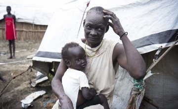 Nyalada Maluit holds her two-year-old son, Lat Machar, in front of their home in the displacement camp on the UN base in Bentiu, South Sudan. Photo: Concern Worldwide.